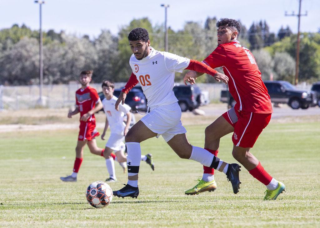 CWC soccer player kicks the ball away from the opposite team